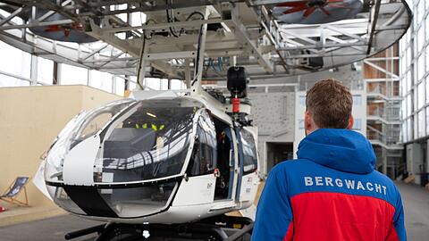 Im Bergwacht-Zentrum für Sicherheit und Ausbildung steht ein Mitglied der Bergwacht Bayern vor einem Hubschrauber-Modell. (Archivbild)